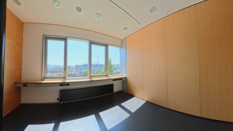 Leerer Büroraum mit großen Fenstern und Stadtblick